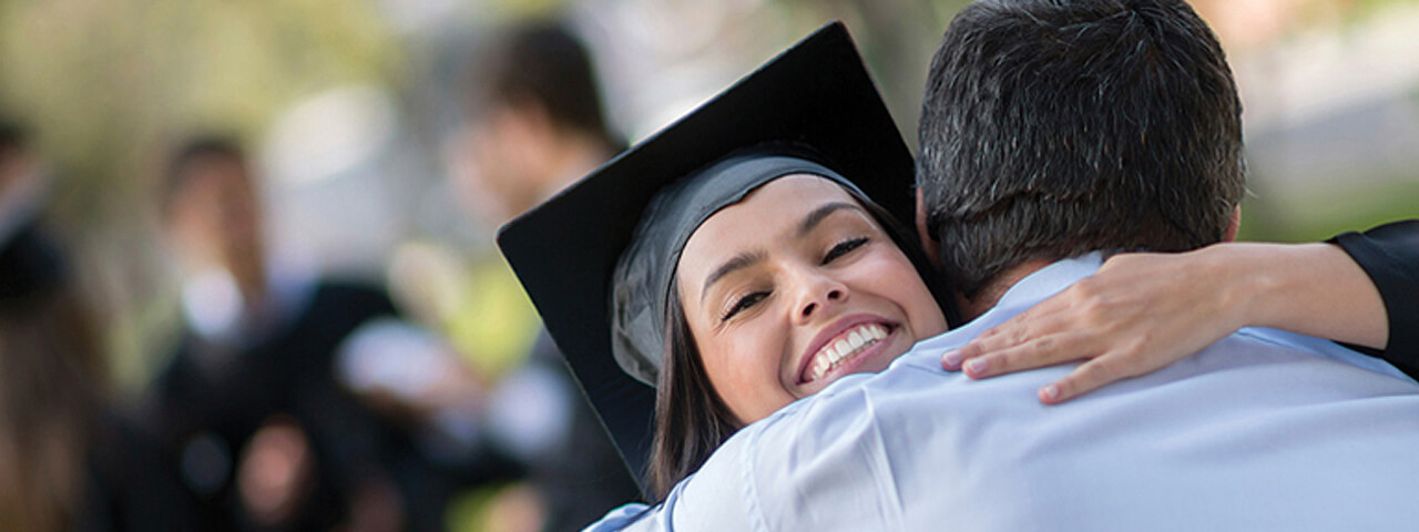 Student hugging parent at graduation.
